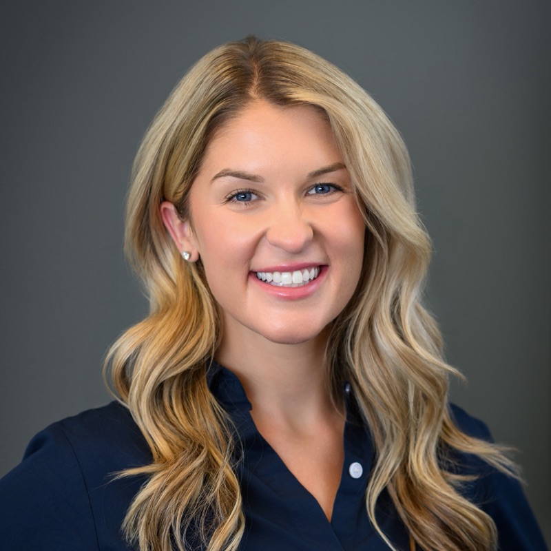 Dr. Paige Wendling, audiologist at the Tinnitus Treatment Center of Philadelphia, smiling in a navy blouse